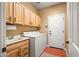 Functional laundry room with a sink, washer, dryer, and ample storage cabinets at 41006 N Noble Hawk Way, Anthem, AZ 85086