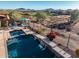 Relaxing pool area with cascading waterfalls, desert landscaping, and mountain views at 41006 N Noble Hawk Way, Anthem, AZ 85086