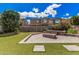 Backyard featuring a paved patio with a stone fire pit, artificial grass, and lush landscaping at 4281 E Mesquite St, Gilbert, AZ 85296