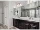 Bathroom featuring a large mirror, double sinks, dark cabinets and tile flooring at 4281 E Mesquite St, Gilbert, AZ 85296