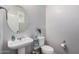 Powder room featuring pedestal sink, oval mirror, and decorative storage at 4281 E Mesquite St, Gilbert, AZ 85296