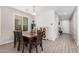 Cozy dining room with wood table and chairs, wood look tile flooring, bright light fixture, and large window at 4281 E Mesquite St, Gilbert, AZ 85296