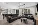 Bright living room with tile floors, two sofas, ceiling fan, media center, and large windows at 4281 E Mesquite St, Gilbert, AZ 85296