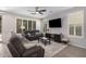 Bright living room with tile floors, ceiling fan, sofa, recliner, media center, and large windows at 4281 E Mesquite St, Gilbert, AZ 85296