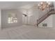 Open-concept living room featuring a staircase, large window, and neutral carpet at 4643 E Villa Maria Dr, Phoenix, AZ 85032