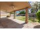 Covered patio with ceiling fan overlooking the lush backyard and inviting pool at 4643 E Villa Maria Dr, Phoenix, AZ 85032