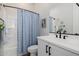 Bright bathroom with a white vanity, black fixtures, and a blue patterned shower curtain at 4834 S Meteor --, Mesa, AZ 85212