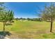 Lush community park with green grass, mature trees, and sprinkler system at 4834 S Meteor --, Mesa, AZ 85212