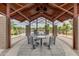 Covered seating area with metal table and chairs offering a view of the surrounding greenery at 4834 S Meteor --, Mesa, AZ 85212