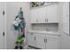 Well-organized laundry room with white cabinets, marble countertops, and patterned floors offers functionality and style at 4834 S Meteor --, Mesa, AZ 85212