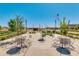 Charming community park featuring metal tables and chairs, lush landscaping, and views of neighborhood homes at 4834 S Meteor --, Mesa, AZ 85212