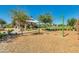 Charming play area featuring a covered seating area and swings, nestled among lush trees and landscaping at 4834 S Meteor --, Mesa, AZ 85212