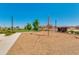 Community playground with climbing structure on a wood chip surface, surrounded by trees and grassy areas at 4834 S Meteor --, Mesa, AZ 85212