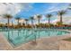 A scenic view of the community pool with palm trees, lounge chairs, and a basketball hoop at 4834 S Meteor --, Mesa, AZ 85212