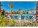 Beautiful community pool featuring a basketball hoop and plenty of lounge chairs surrounded by mature palm trees at 4834 S Meteor --, Mesa, AZ 85212