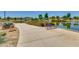 Tranquil walking path alongside a community lake with benches, lush greenery, and peaceful reflections at 4834 S Meteor --, Mesa, AZ 85212