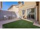 Inviting backyard with artificial turf, paver patio, block wall, and sliding door access to the home at 504 N Ranger Trl, Gilbert, AZ 85234