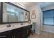 Bathroom featuring dual sinks, large mirror, decor, and window with blinds at 504 N Ranger Trl, Gilbert, AZ 85234