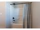 Bright bathroom featuring a white tub/shower combination with modern black fixtures and a neutral patterned curtain at 504 N Ranger Trl, Gilbert, AZ 85234