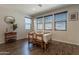 Well-lit dining area with wood floors, table setting, and three large windows at 504 N Ranger Trl, Gilbert, AZ 85234