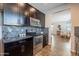 Kitchen showcasing stainless steel appliances, dark wood cabinetry, granite countertops, and seamless access to dining area at 504 N Ranger Trl, Gilbert, AZ 85234