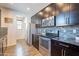 Modern kitchen featuring stainless steel appliances, dark wood cabinets, and stylish backsplash and wood flooring at 504 N Ranger Trl, Gilbert, AZ 85234