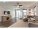 Bright living room with hardwood floors, a cozy sofa, and natural light streaming through large windows at 504 N Ranger Trl, Gilbert, AZ 85234