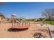 This community playground features swings, a slide, picnic pavilion, and bench for relaxing at 504 N Ranger Trl, Gilbert, AZ 85234