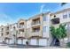 Building exterior featuring garages, balconies, and well-maintained landscaping at 5302 E Van Buren St # 2060, Phoenix, AZ 85008