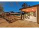 A covered patio with outdoor dining space looks out to the yard and pool at 5507 N Calle Del Santo --, Phoenix, AZ 85018