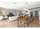 Bright dining area with a wooden table, modern chandelier, and open layout to the living room and kitchen at 5507 N Calle Del Santo --, Phoenix, AZ 85018