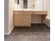 Modern bathroom vanity with wood cabinets, sleek countertop, and dark tile flooring at 559 E Rainbow Dr, Chandler, AZ 85249