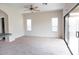 Open living space with neutral carpet, ceiling fan, sliding glass door, and bright, natural light at 559 E Rainbow Dr, Chandler, AZ 85249