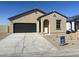 Inviting single-story home featuring a neutral color palette, arched entryway, dark garage door and desert landscaping at 5722 E Orion Rd, Florence, AZ 85132