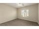 A bright bedroom with neutral walls and carpet, featuring a ceiling fan and plantation shutters at 5826 E Nathan St, Mesa, AZ 85215