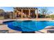 Sparkling community pool with seating, covered pergola, and nearby restroom facility at 5826 E Nathan St, Mesa, AZ 85215