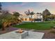 Beautiful modern house with lush green lawn, firepit and view of distant mountains at sunset at 6216 N 38Th Pl, Paradise Valley, AZ 85253