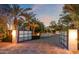 Elegant driveway with brick pavers and palm trees leading to a modern home at dusk at 6216 N 38Th Pl, Paradise Valley, AZ 85253