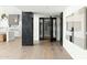 Hallway with hardwood flooring, a modern wine cellar, and art; the kitchen is in the background at 6216 N 38Th Pl, Paradise Valley, AZ 85253