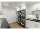 Modern laundry room with stacked washer/dryer units, sleek cabinets, and dark countertops at 6216 N 38Th Pl, Paradise Valley, AZ 85253