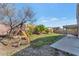 Spacious backyard featuring a covered patio and a play structure, perfect for outdoor activities at 648 W Cobblestone Dr, Casa Grande, AZ 85122