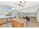 Open kitchen with granite island, stainless steel sink, and tile flooring extending into the dining area at 648 W Cobblestone Dr, Casa Grande, AZ 85122