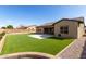 Backyard featuring artificial turf, a stone retaining wall, and desert landscaping at 7630 E Knoll St, Mesa, AZ 85207