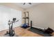 A home gym with exercise bike, rowing machine, and hardwood floors at 7630 E Knoll St, Mesa, AZ 85207