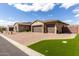 Exterior view of the three car garage with brick paver driveway and well manicured lawn at 7630 E Knoll St, Mesa, AZ 85207