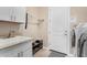 Laundry room featuring a utility sink, cabinets, and white doors at 7630 E Knoll St, Mesa, AZ 85207