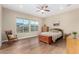 Bright bedroom featuring hardwood floors, a ceiling fan, and large windows with backyard views at 7630 E Knoll St, Mesa, AZ 85207