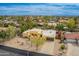 Aerial view showcasing a yellow house in a community with desert landscaping and tile roofs at 7719 W Bluefield Ave, Glendale, AZ 85308