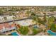 Aerial view of a desert community featuring various pools, greenery, and a yellow house at 7719 W Bluefield Ave, Glendale, AZ 85308