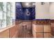 Walk-in shower showcasing a unique blue tile design and brick floors in the bathroom at 7719 W Bluefield Ave, Glendale, AZ 85308